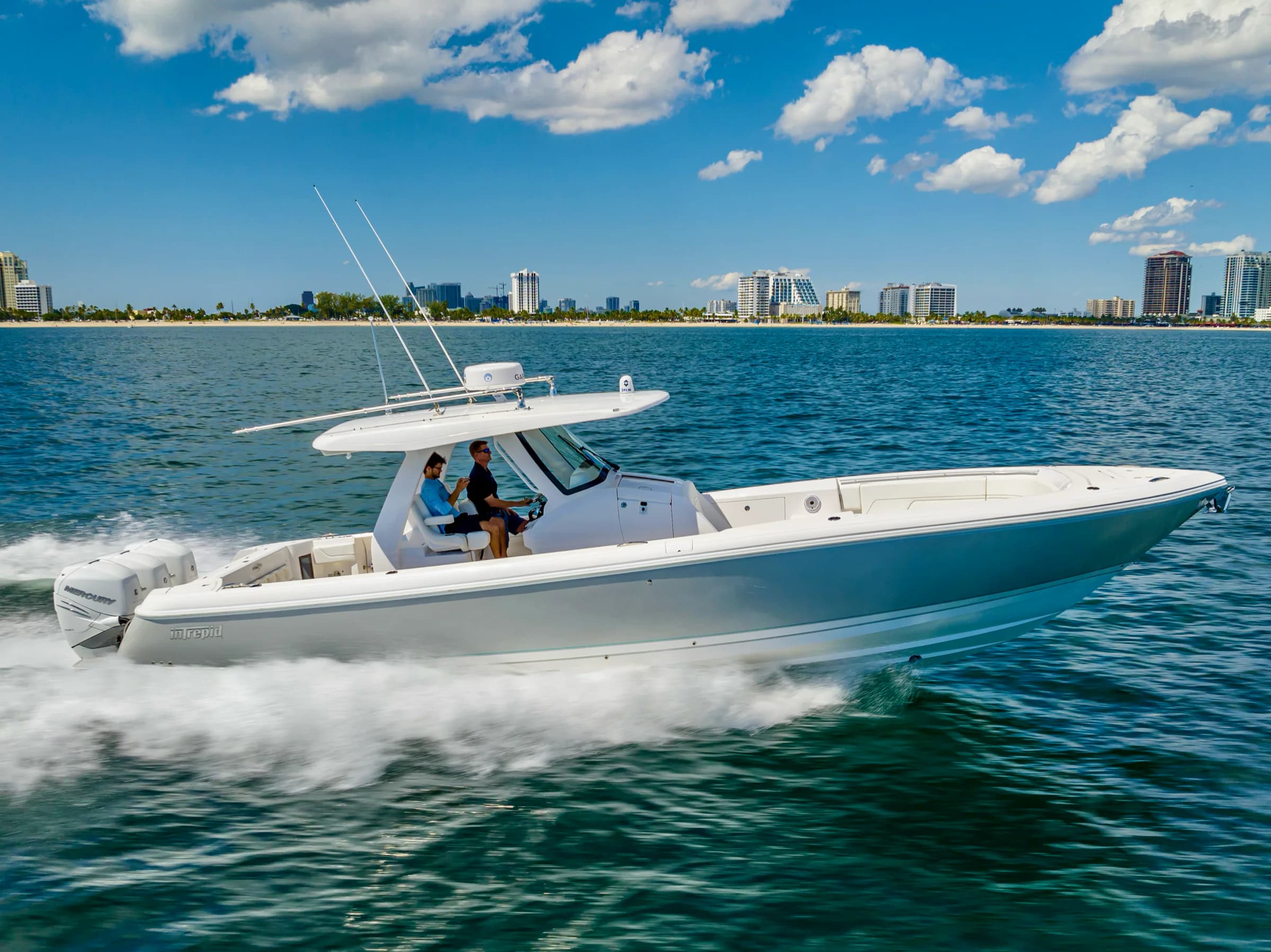 A pale grey Intrepid center console under way beneath a sky of white clouds